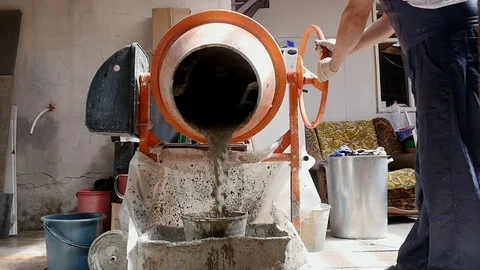 Man pours the solution from the concrete mixer into the bucket 스톡 동영상 80296144