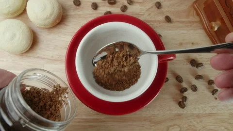 Man pours a spoon of coffee into a cup. slow motion pouring instant coffee into Stock Footage 260689901