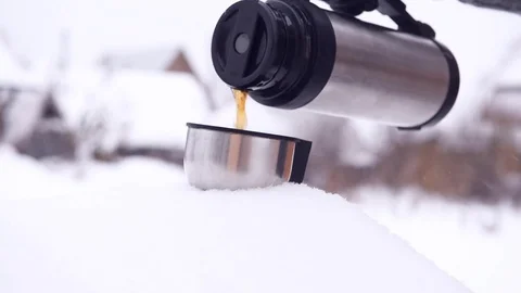 Man pours tea from a thermos. Winter, snow, cold. Stock Footage 70750033
