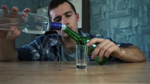 A man pours vodka from one bottle to another Stock Footage 155106162
