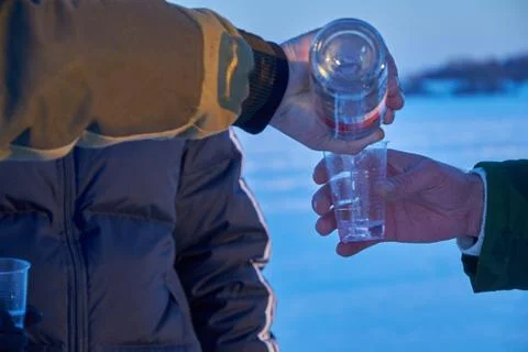 Man pours vodka into plastic Cup Stock Photos