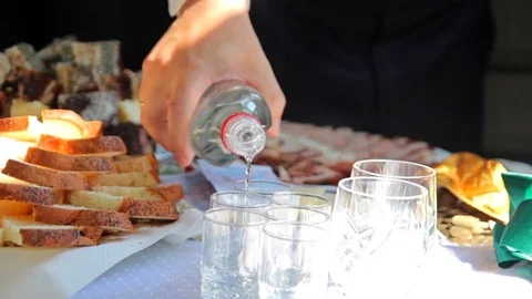 Man pours vodka into wine glasses. Redemption of the bride. Wedding tradition Vídeo Stock 80396543