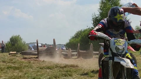 A man pours water on a competitor on a hot, sultry summer day during motocross Stock Footage 172178830