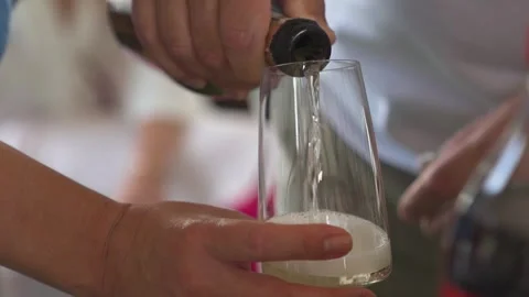 A man pours white wine or champagne into a glass. Close-up view Stock Footage 293973833