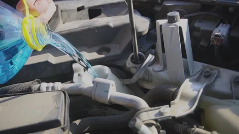 A man pours windshield washer fluid into a car Stock Footage 321174583