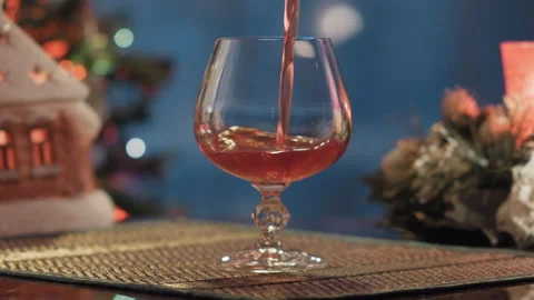Man pours wine into a glass against the background of an evening window Stock Footage