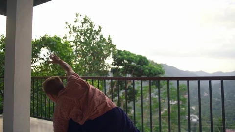 Man practice extended side agle yoga pose at balcony sunrise rapid slow motion Stock Footage 86645523