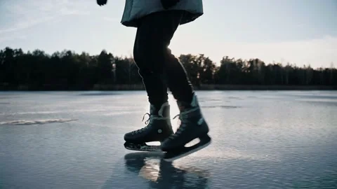 Man practice ice skating on a clear frozen lake on sunny day in nature Video stock 170161695