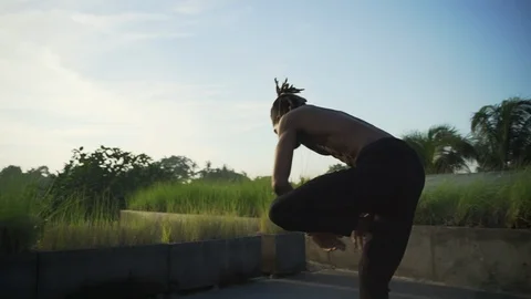 Man practice toe stand yoga asana at roof top solar battery rapid slow motion Stock Footage 89727617