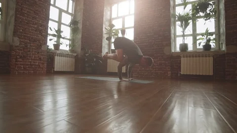 Man practice yoga pose in studio with sunbeams. Attractive man making yoga pose Video stock 108533587