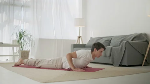 Man Practice Yoga Sun Salutation. Body Care Morning Routine at Cozy Interior Stock Footage 134728926