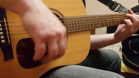 Man practices guitar at home during quarantine Stock Footage 128889412