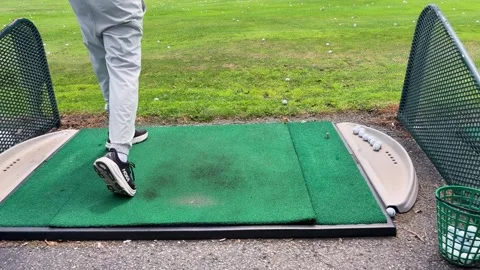 A man practices his golf swing on an outdoor driving range in Toronto, Canada. Stock Footage 343672806