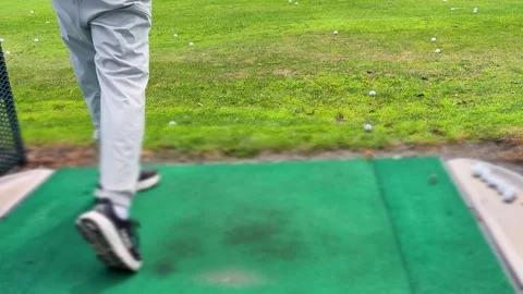 A man practices his golf swing on an outdoor driving range. Video stock 344558102
