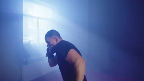 A man practices Muay Thai kicks while training in the gym. Video stock 236049705