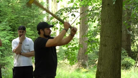 Man practicing axe throwing technique in forest during bushcraft and survival Stock Footage 330970634