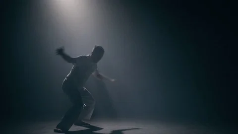 Man practicing capoeira in dark room Stock Footage 83550573