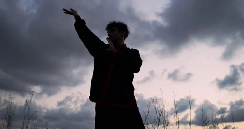 Man practicing chikung during a sunrise on a mountain Stock Footage 136026818