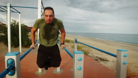 Man practicing dips on parallel bars outdoors on playground Stock-Footage 219481536