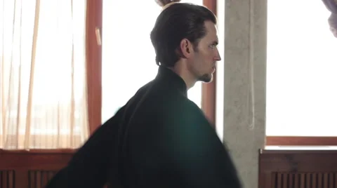 Man practicing elements of tai chi. The man rotating steel swords around a body 库存影片 64463556