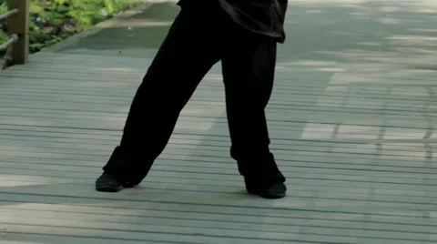 Man practicing elements of tai chi. A man rotating steel swords around a body HD 库存影片 65214780