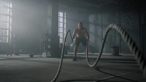 Man practicing exercise with battle ropes. Sportsman doing functional training 写真素材