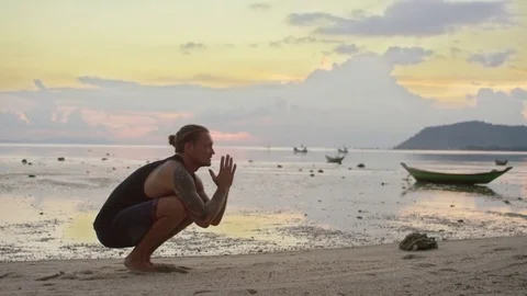 Man practicing handstand in the sea at sunset Stock Footage 74774304