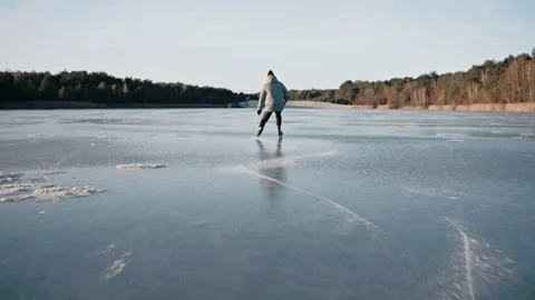 Man practicing ice skating on a clear frozen lake on a sunny winter day Vídeo Stock 170161706