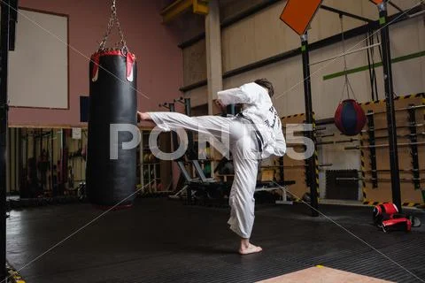 Man Practicing Karate With Punching Bag