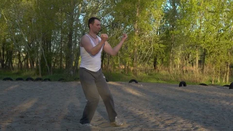 Man Practicing Martial Arts on the Sand in the Park,performing the Kata of Stock Footage 75156584