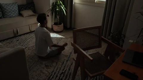 Man practicing mindfulness at home during a work break, sitting quietly between 库存影片 347304291