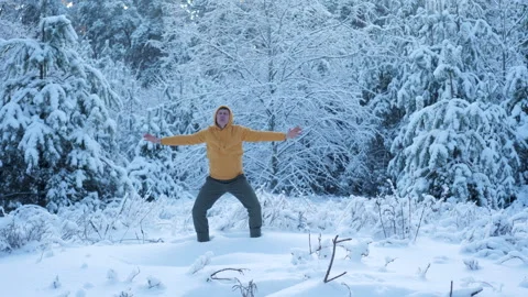 Man practicing qigong breathing exercise in snowy winter forest Stock Footage 334374575