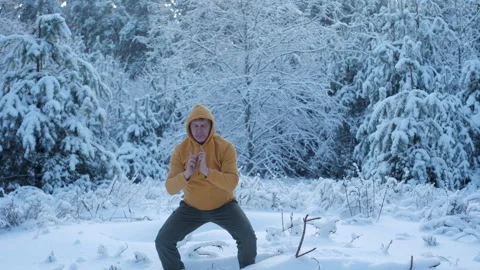 Man practicing qigong breathing exercise in snowy winter forest Stock Footage 337055829