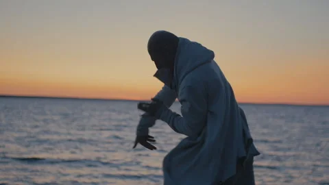 Man Practicing Qigong At Sunset By The Sea. Slow-mo. Cinematic Stock Footage 117194341
