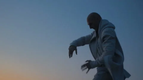 Man Practicing Qigong At Sunset By The Sea. Slow-mo. Cinematic Stock Footage 117194385