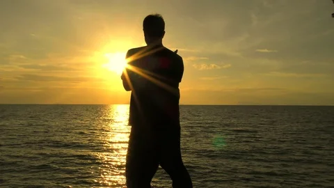 Man is practicing self-defence technique on the sea at sunset. Self Defence Stock Footage 81207937