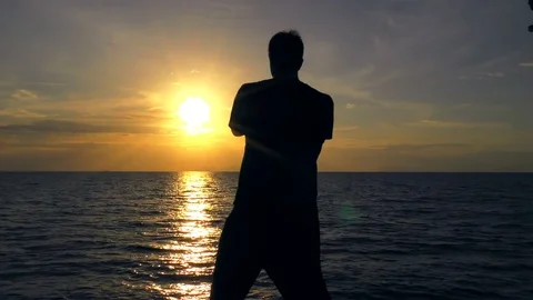 Man is practicing self-defence technique on the sea at sunset. Self Defence Stock Footage 81217344