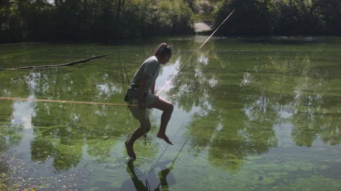 Man practicing slackline over the surface of the river 스톡 동영상 140338593