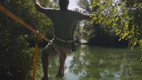 Man practicing slackline over the surface of the river 스톡 동영상 140338693