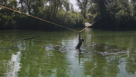 Man practicing slackline over the surface of the river 스톡 동영상 140680332
