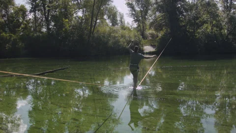 Man practicing slackline over the surface of the river 스톡 동영상 140680549