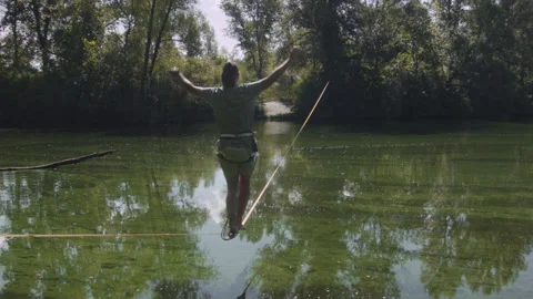 Man practicing slackline over the surface of the river 스톡 동영상 140680630