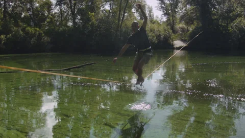Man practicing slackline over the surface of the river 스톡 동영상 140683878