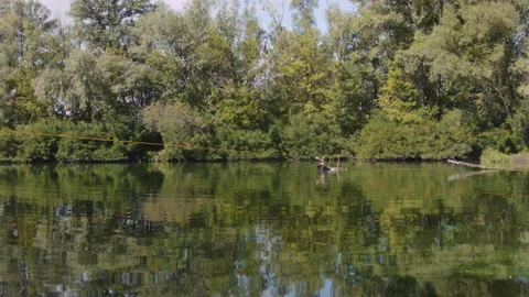 Man practicing slackline over the surface of the river 스톡 동영상 140690175