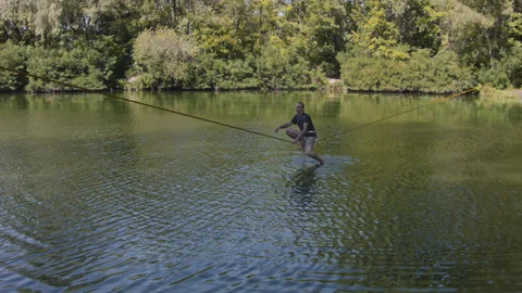 Man practicing slackline over the surface of the river 스톡 동영상 140694350