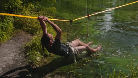 Man practicing slackline over the surface of the river 스톡 동영상 140761263
