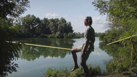 Man practicing slackline over the surface of the river 스톡 동영상 140812184