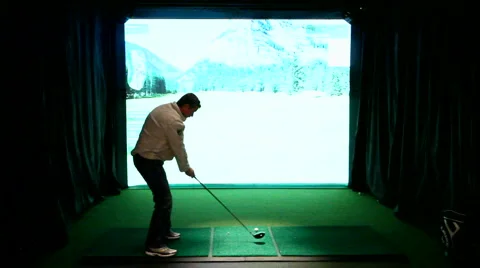 Man practicing swing with an indoor golf simulator Stock Footage 1094203