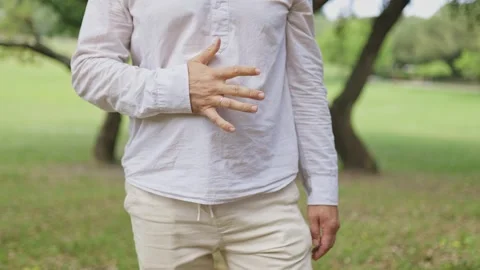 Man practicing tai chi breathing exercises outdoors Stock Footage 323363470
