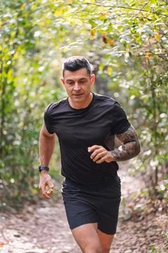 Man practicing trail running in the forest Stock Photos